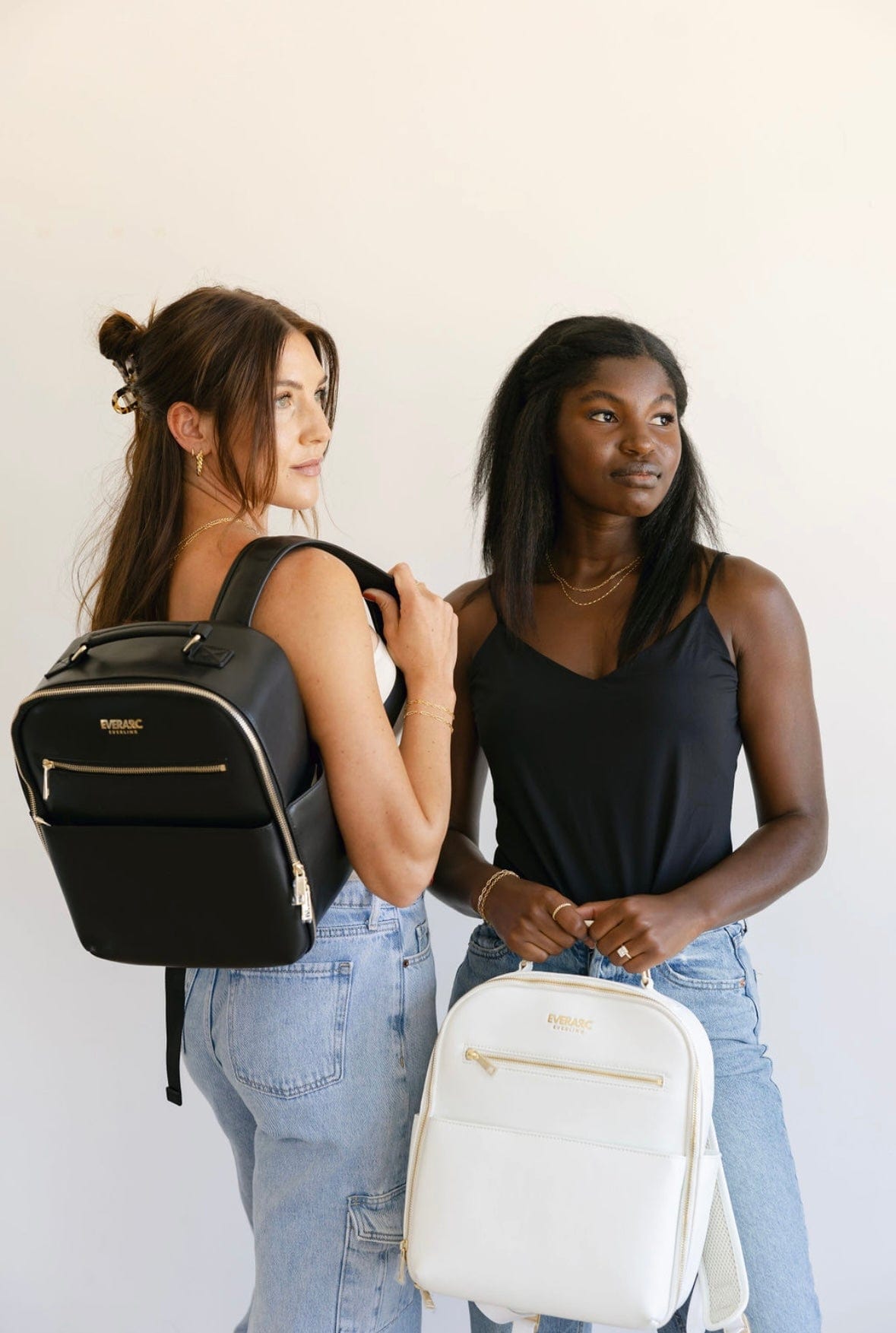 Two women with black and white backpacks.