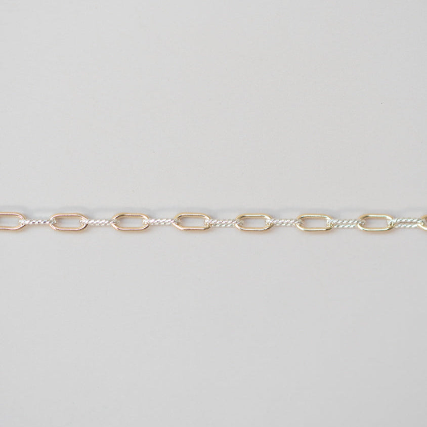Gold chain on a light gray background