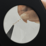 Jewelry chain repair under magnification, screenshot May 12, 2025.