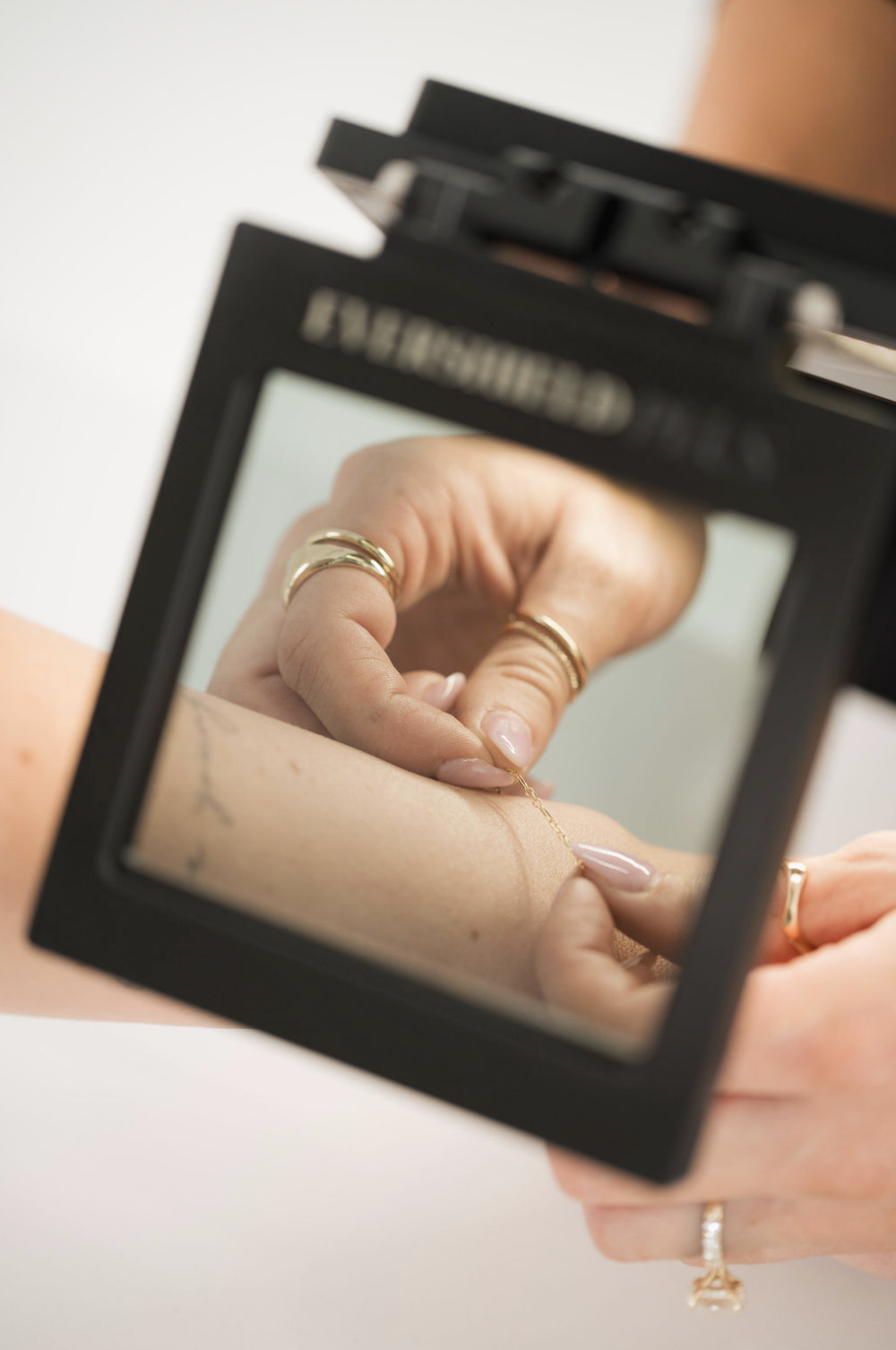 Hand with rings reflected in a mirror.