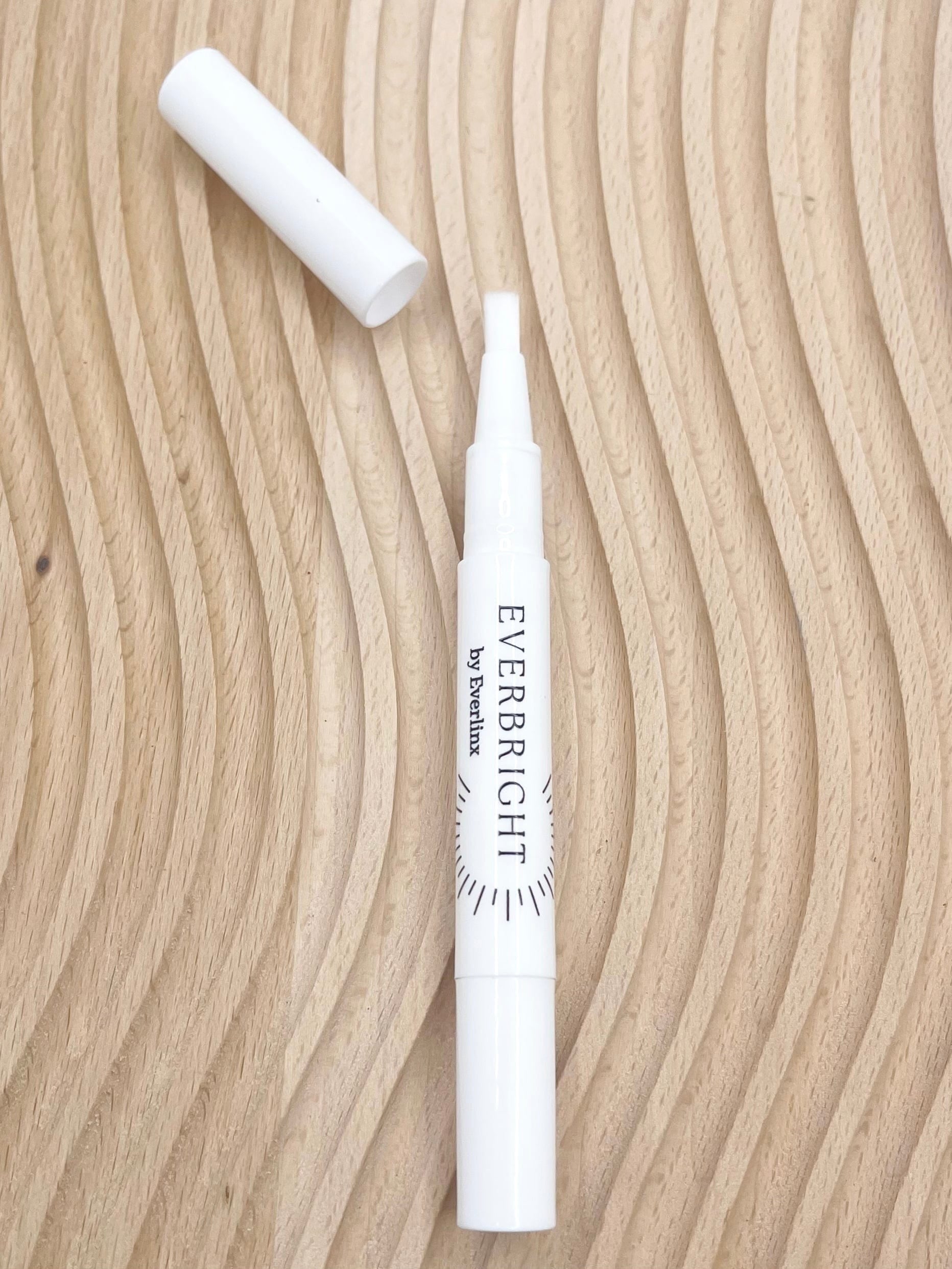 Everbright teeth whitening pen on wood grain