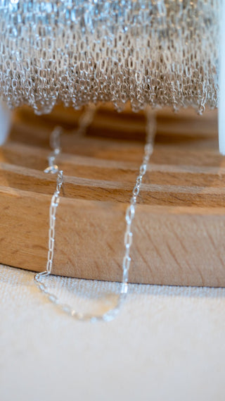 Silver chain necklace (024BFBCE) displayed on wooden stand.