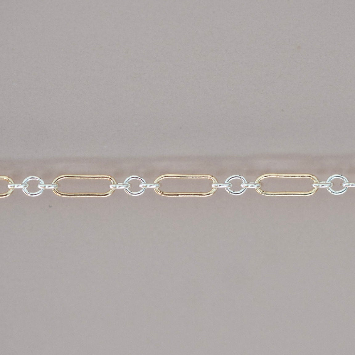 Gold and silver chain on a gray background