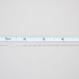 Gold chain with a ruler for scale on a white background