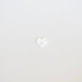 Small white heart with a face emoji on a light gray background