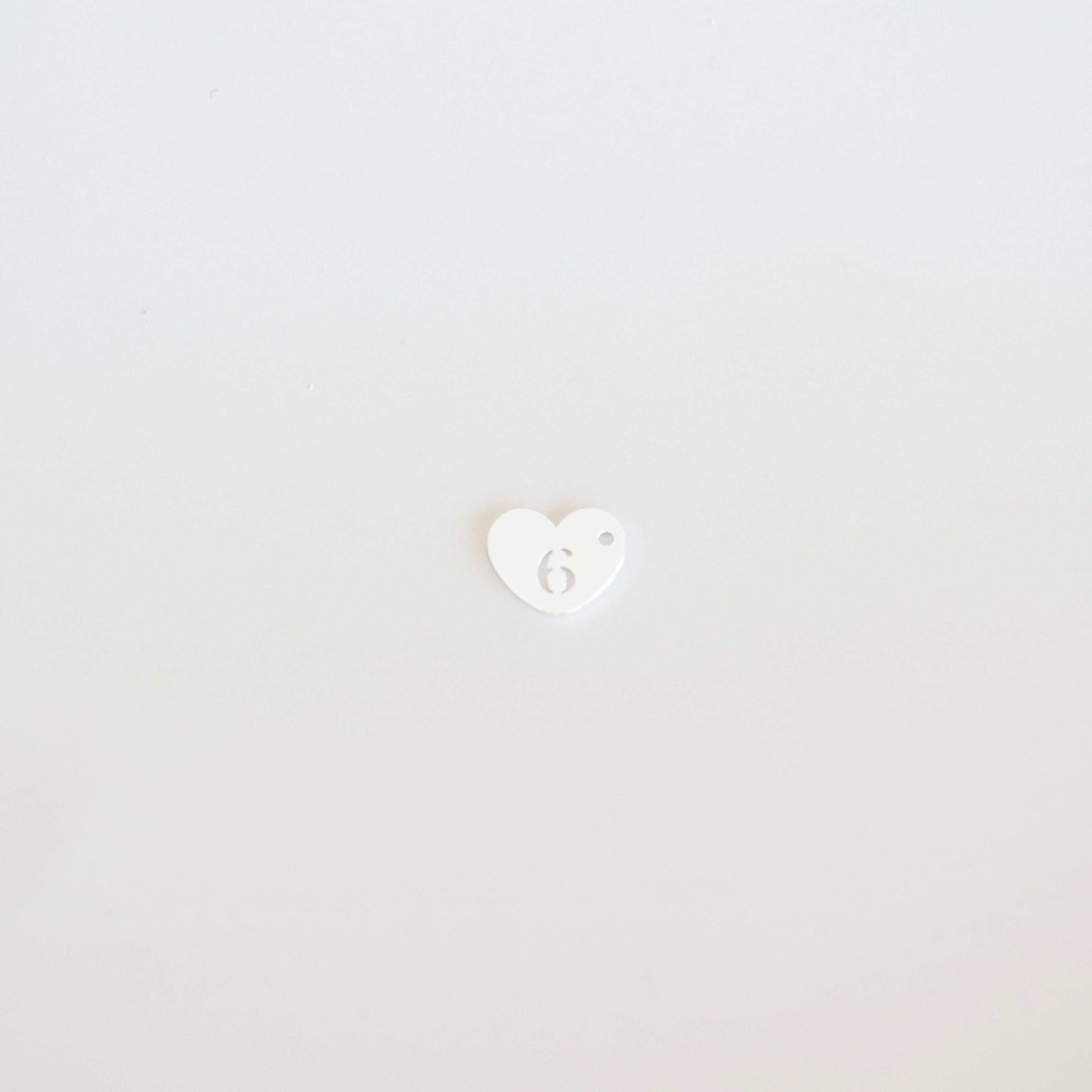 Small white heart with a face emoji on a light gray background