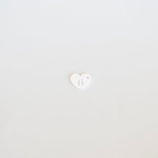Small white heart with a face emoji on a light gray background