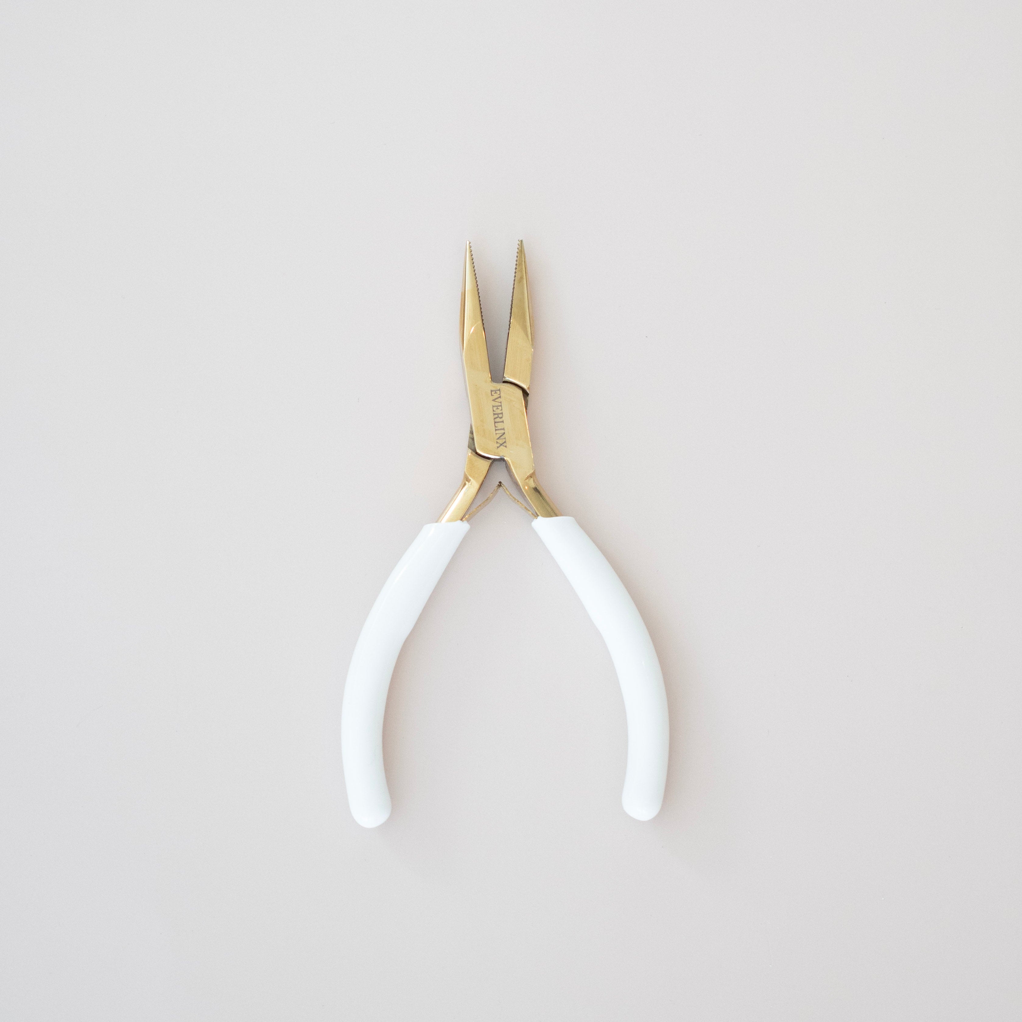 Pair of pliers with white handles on a light gray background