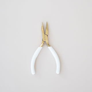 Pair of pliers with white handles on a light gray background
