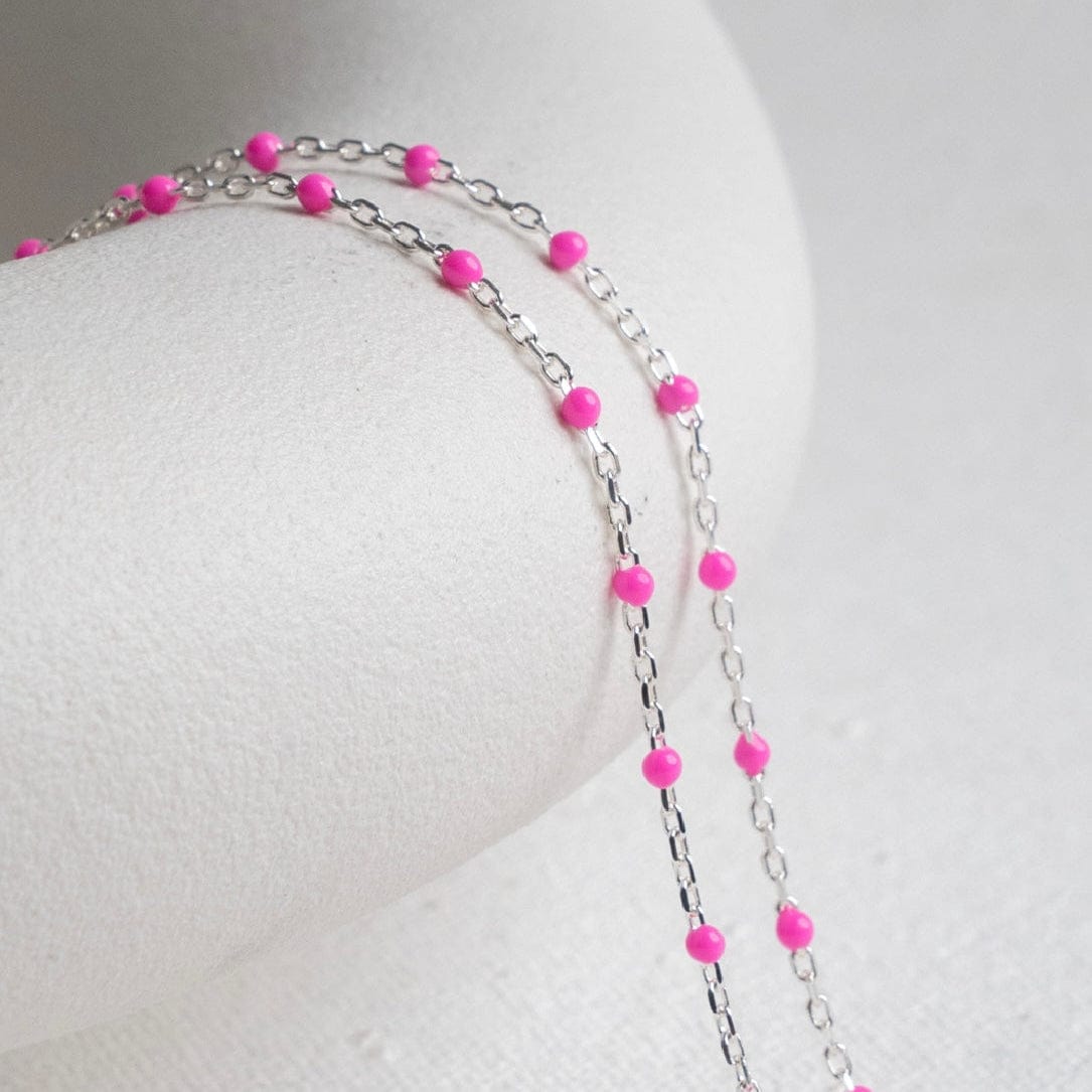 Pink beaded necklace on white background