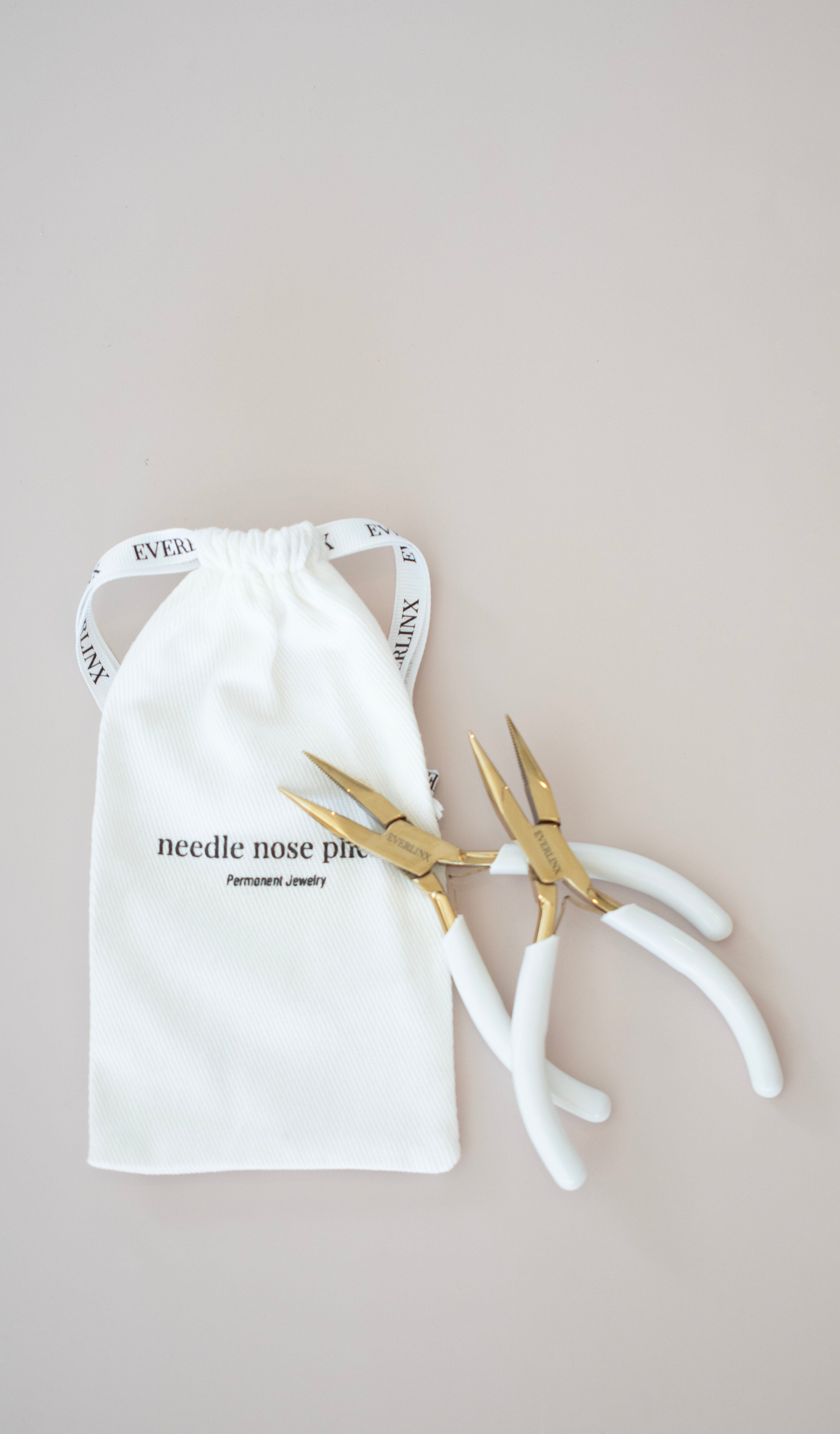 Pair of gold pliers on a white drawstring bag with text on a beige background