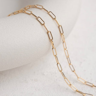 Gold chain necklace on white surface