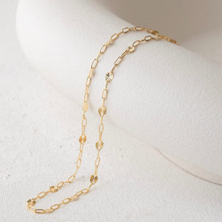 Gold chain necklace on white display