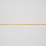 Gold chain on a light gray background