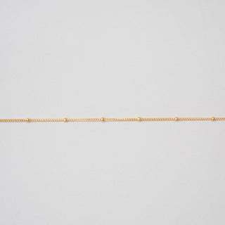 Gold chain on a light gray background