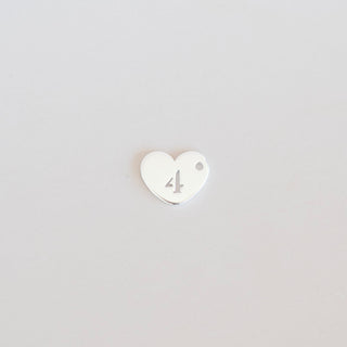 Heart-shaped number '4' charm on a light gray background
