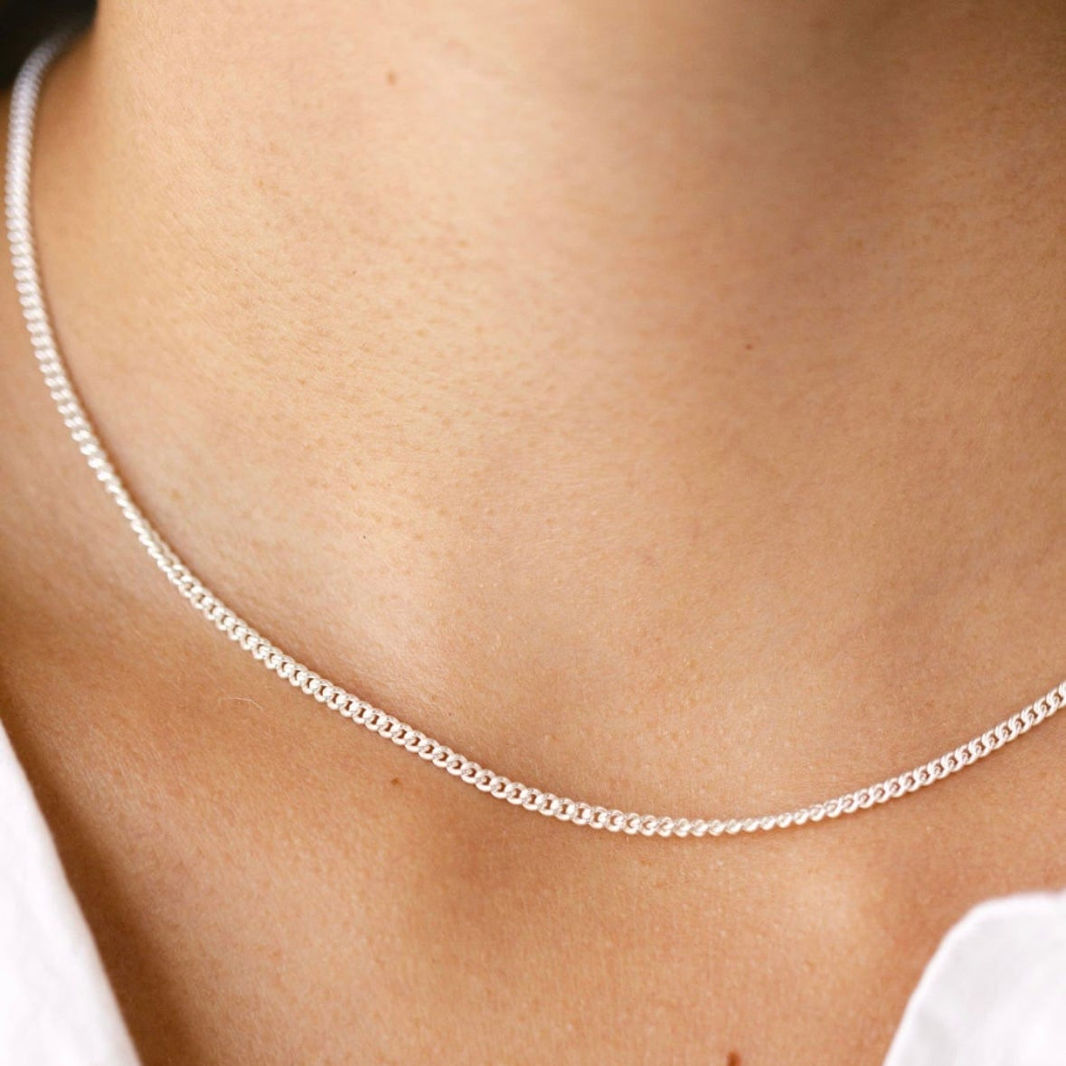 Silver chain necklace on a person's neck