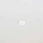 White heart-shaped object on a light gray background