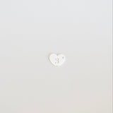 White heart-shaped object on a light gray background