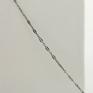 Delicate silver chain on a white surface