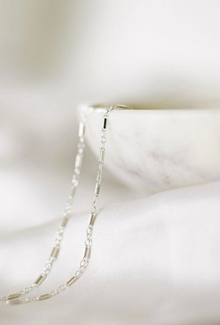 Silver chain necklace in bowl, product image...