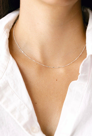 Woman wearing a silver necklace.