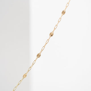 Gold chain necklace with floral accents.
