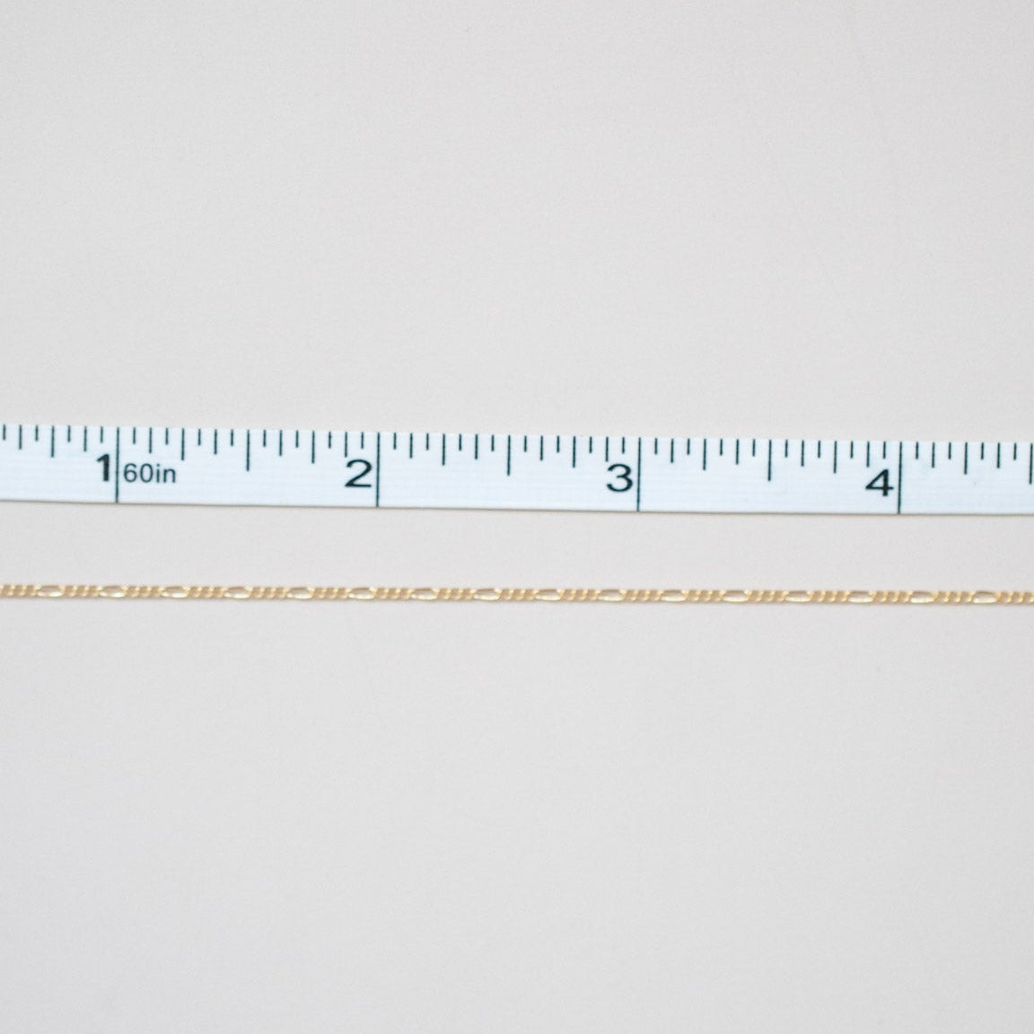 White fabric with a ruler at the bottom for scale on a white background