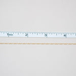 White fabric with a ruler at the bottom for scale on a white background