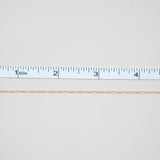 White fabric with a ruler at the bottom for scale on a white background