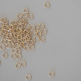 Gold jump rings scattered on a gray background