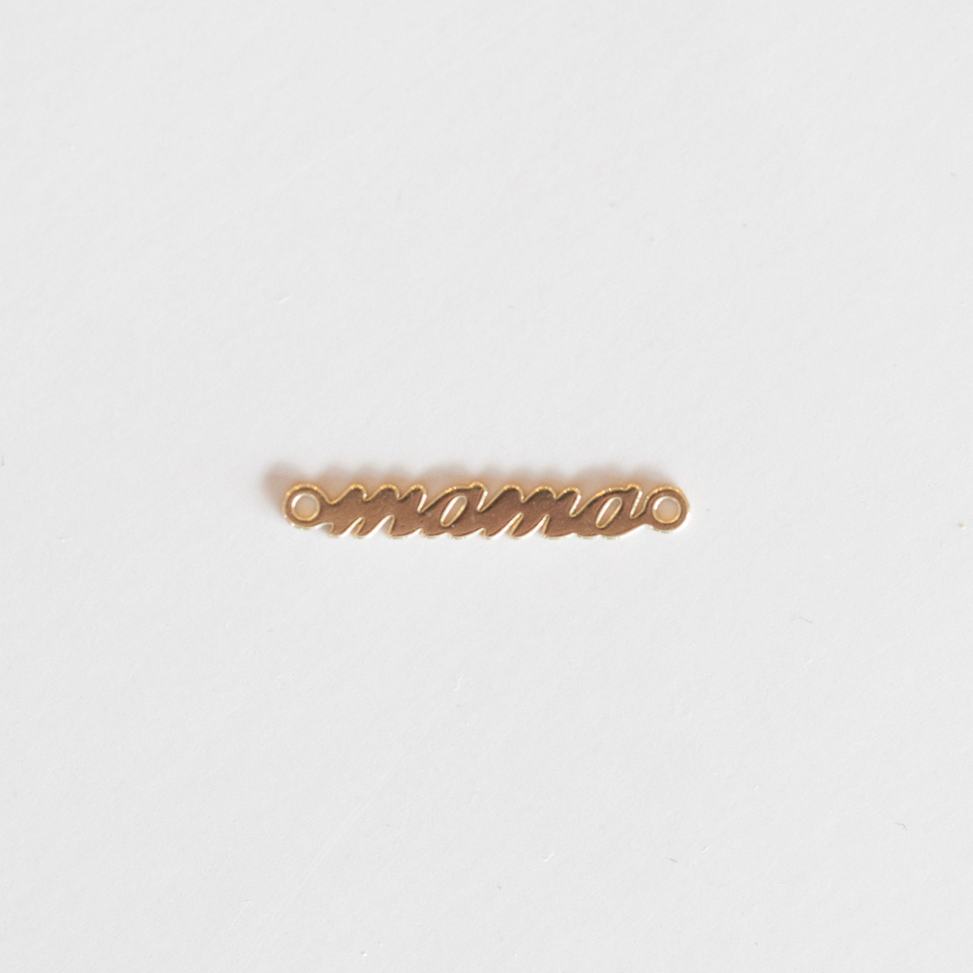 Gold 'mama' charm on a white background