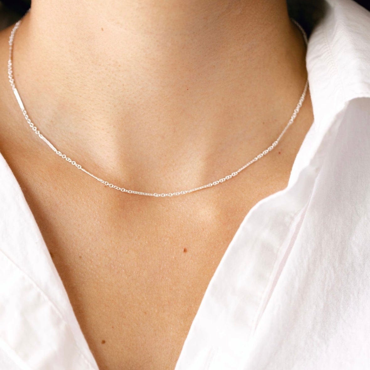 Silver necklace on white shirt
