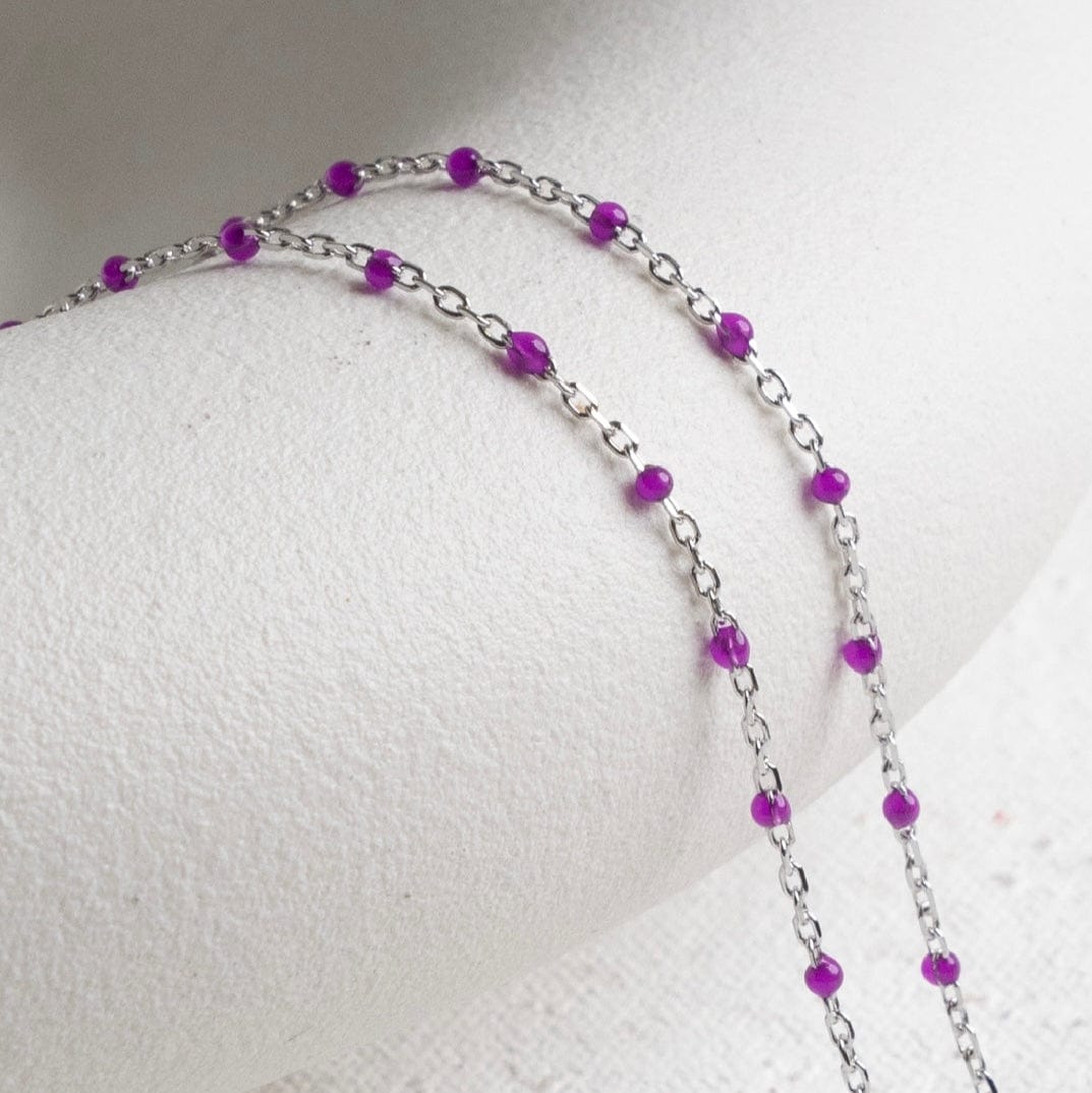 Purple beaded necklace on white display