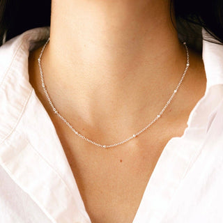 Silver beaded necklace on a white shirt