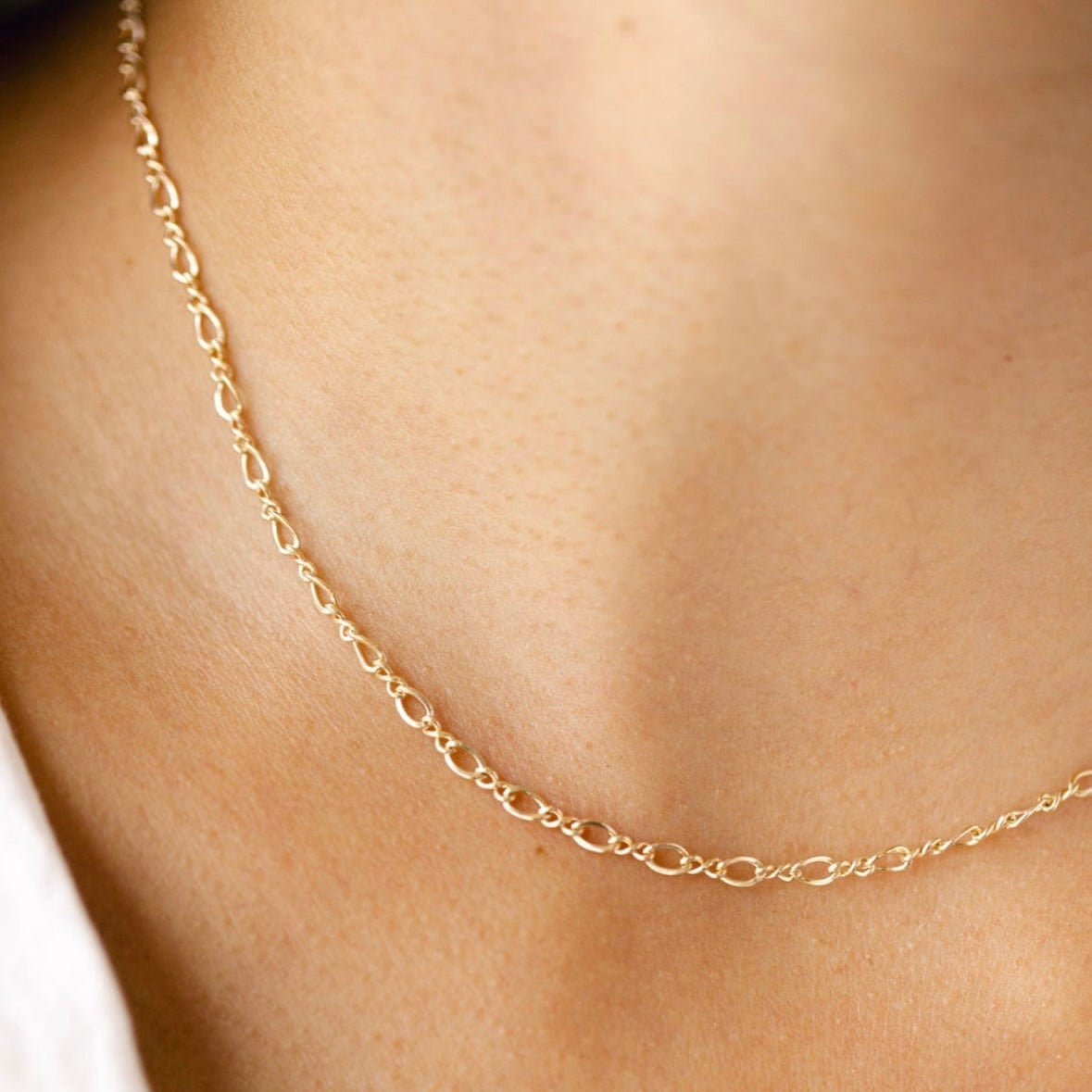 Gold chain necklace on a person's neck