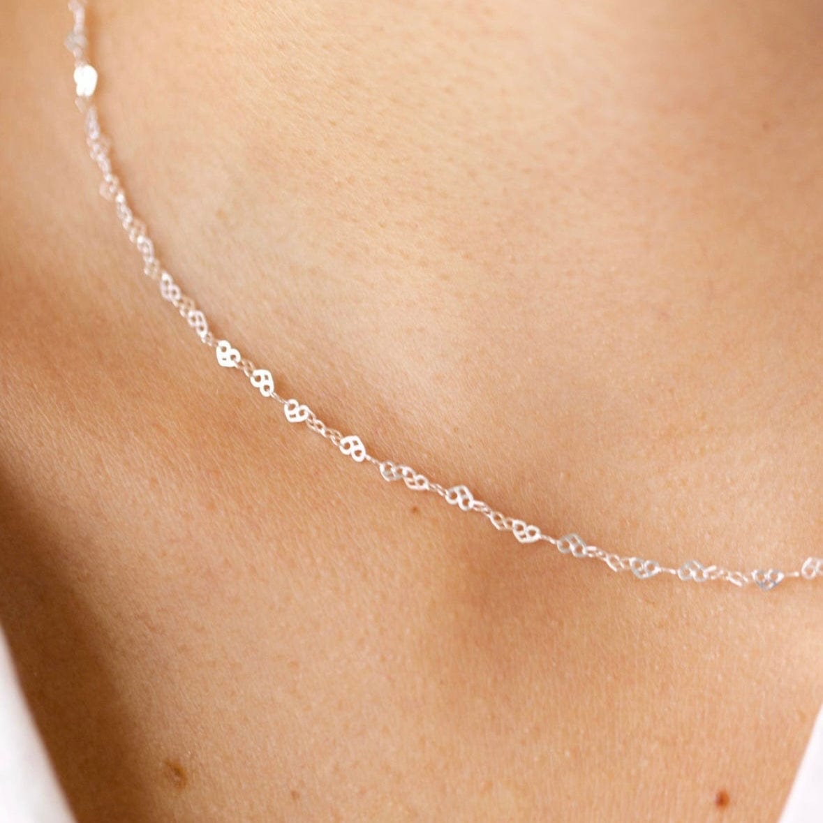 Delicate silver necklace on a woman's neck - 94E49694-9764