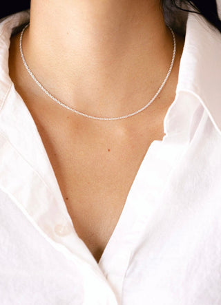 Delicate silver necklace on white shirt