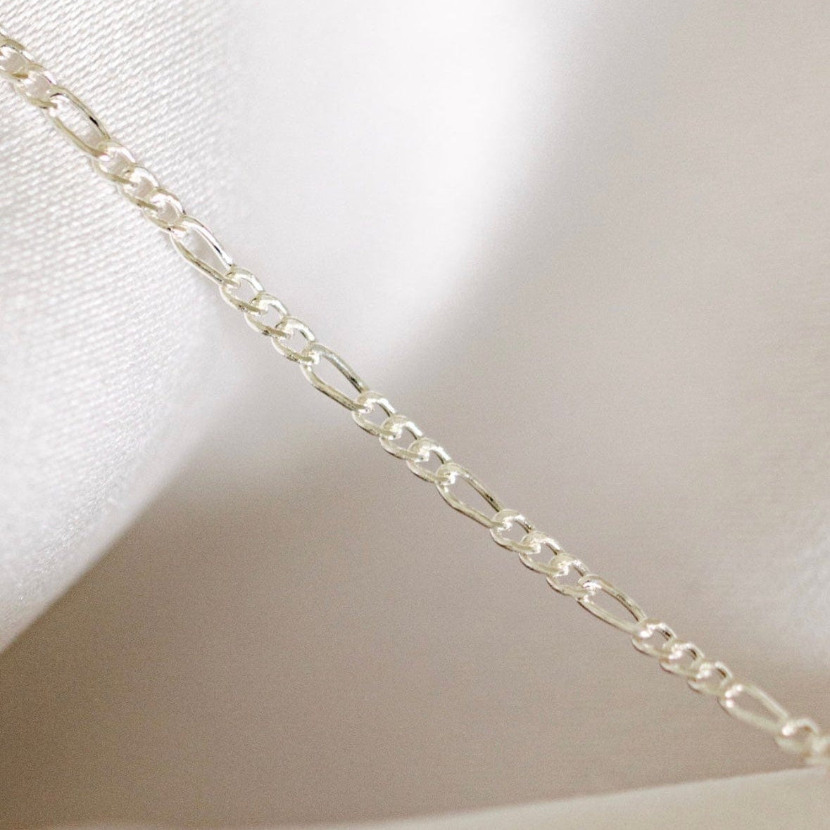 Silver Figaro chain necklace detail