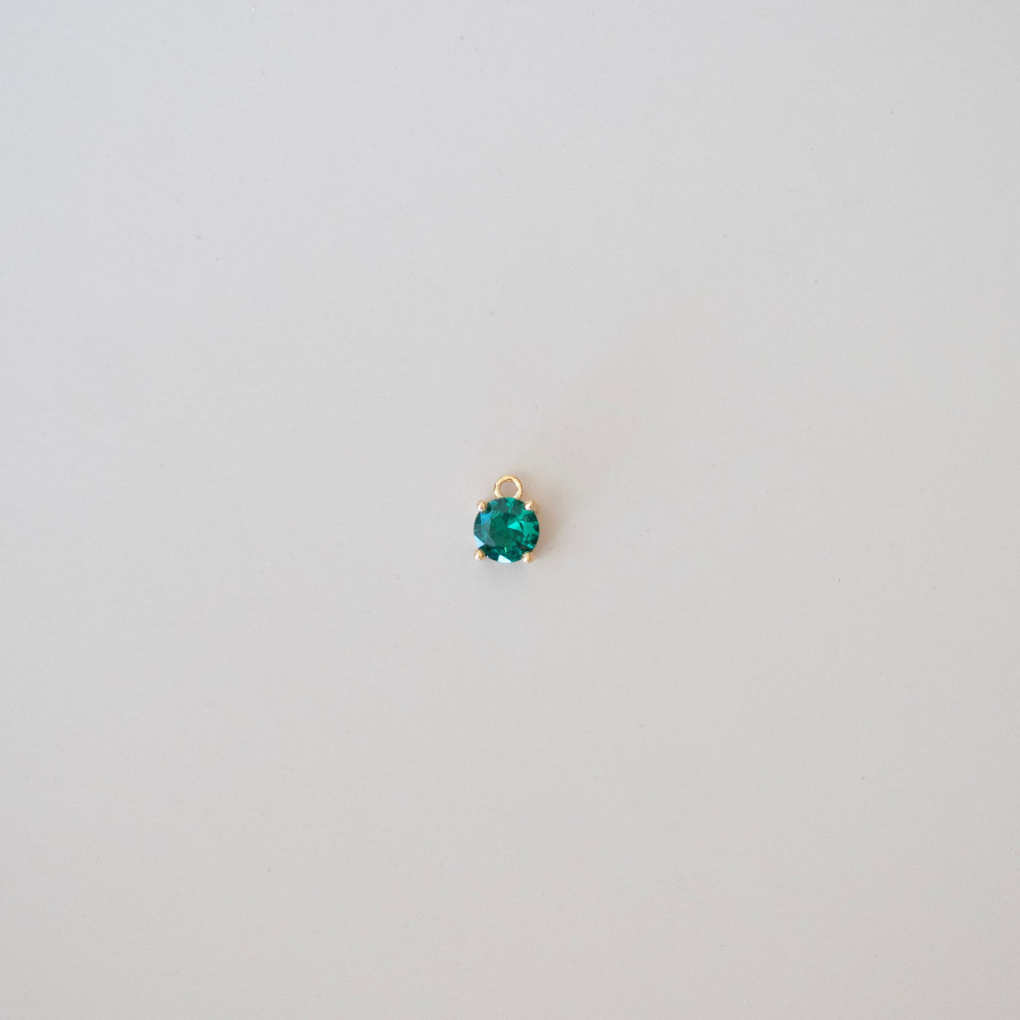 Single emerald green gemstone on a white background