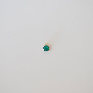 Single emerald green gemstone on a white background