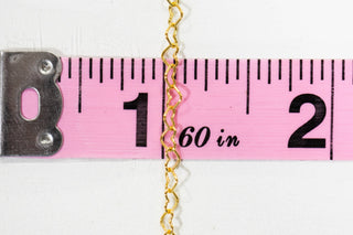 Gold chain measuring 1 inch on pink tape measure
