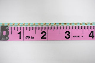 Mint green and gold chain next to a ruler