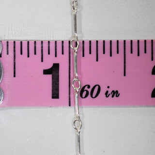 Silver chain measured with ruler, 1-2 inches.
