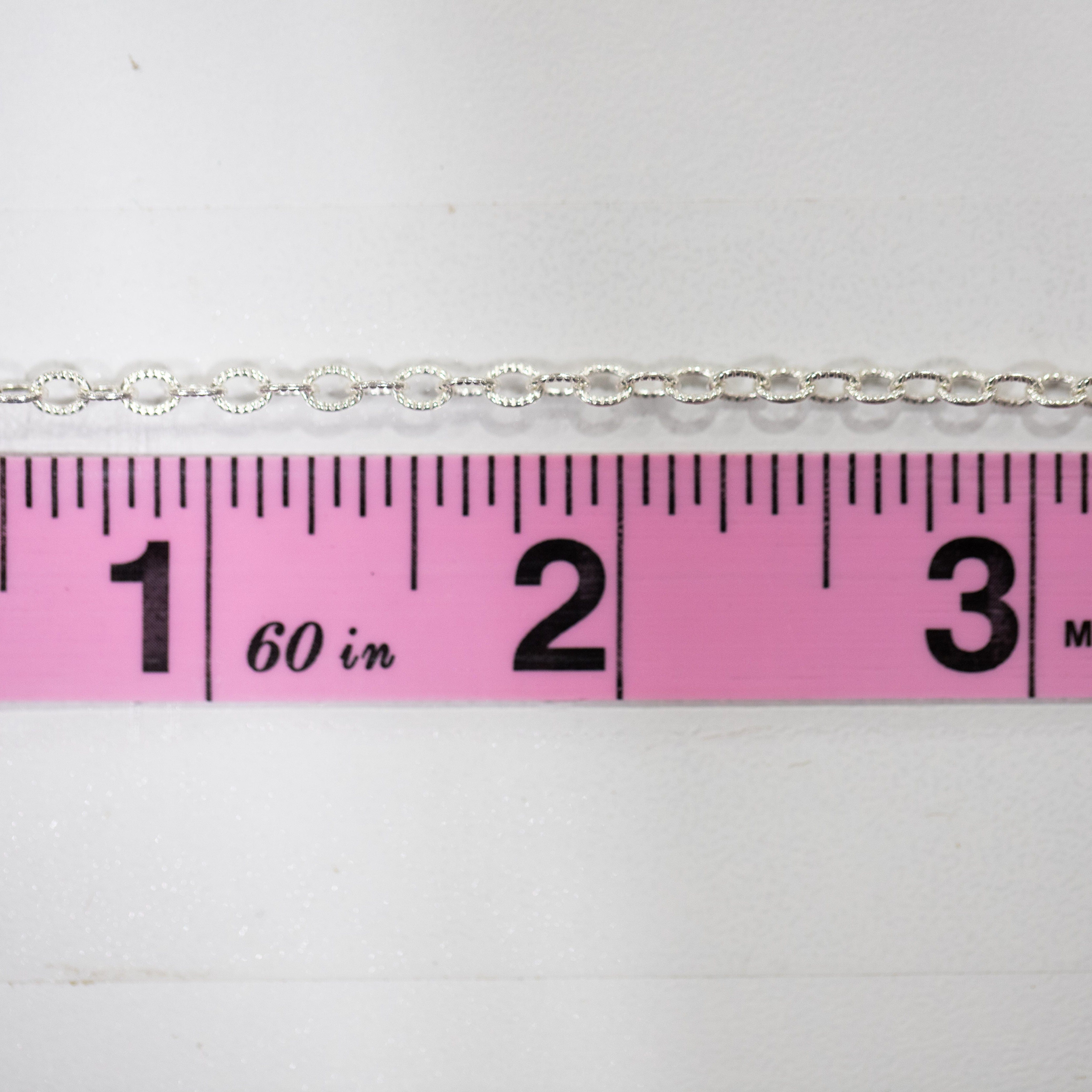 Silver chain necklace measured with a ruler