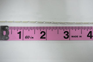 Silver chain necklace next to ruler, 56 inches