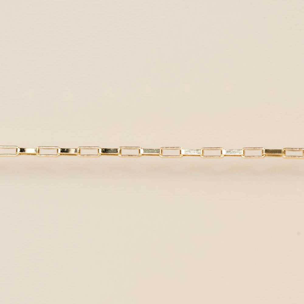 Gold bracelet on a beige background