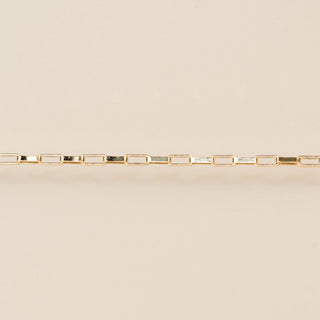 Gold bracelet on a beige background