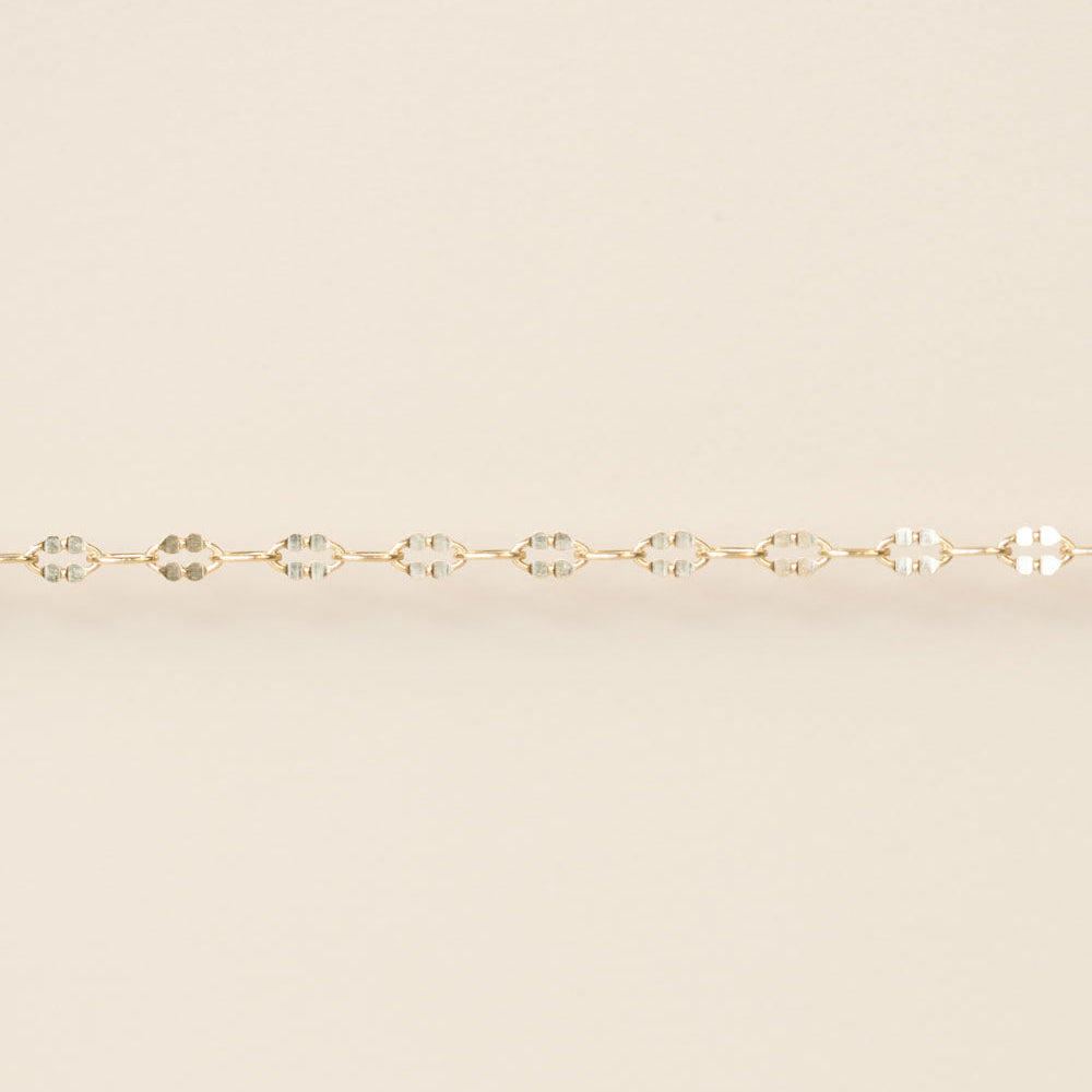 Gold bracelet on a beige background