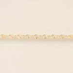 Gold bracelet on a beige background